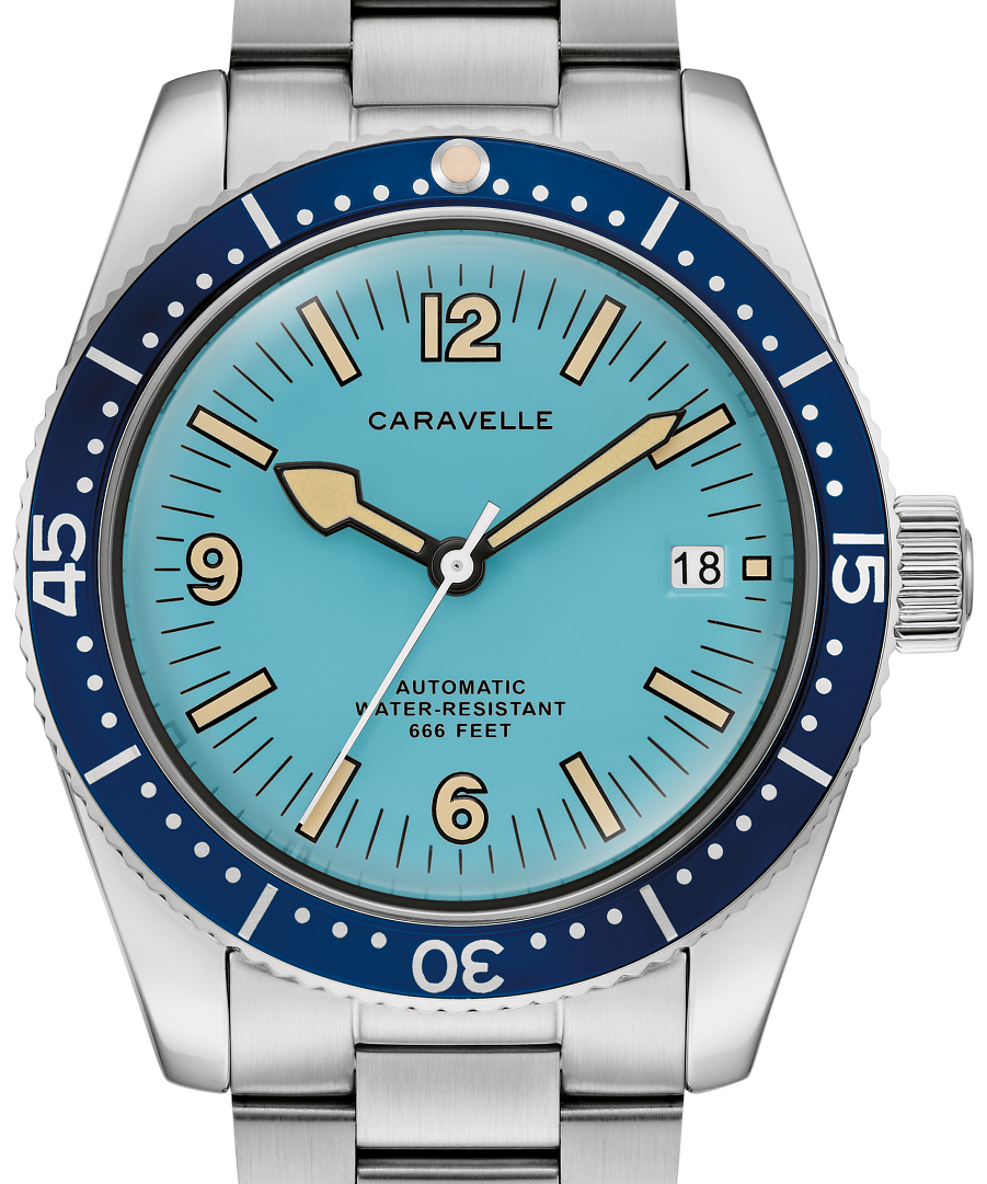 A Caravelle automatic dive watch with a stainless steel link bracelet, featuring a light blue dial, a dark blue bezel with white numerals, and gold-tone hands and indices.
