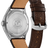 Citizen Eco-Drive watch shown from the back, featuring a silver stainless steel case and a dark brown leather strap with a tan interior lining.