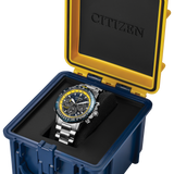 Citizen watch presented in an open hard case with a blue exterior, yellow interior frame, and black cushion. The watch has a silver-toned metal case, a black dial with yellow accents, and a black bezel.