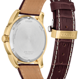 Citizen watch shown from the back, featuring a gold-tone case, brushed stainless steel case back, and a dark brown leather strap with white contrast stitching and a gold-tone buckle engraved with CITIZEN.