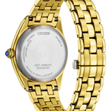Citizen gold-tone stainless steel watch shown from the back, featuring a gold link bracelet, a silver-toned circular case back with engraved details, and a small blue accent cabochon on the crown.