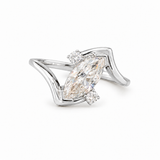A silver-tone ring featuring a marquise-cut diamond center stone with smaller round diamonds on either side, set against a clean white background.