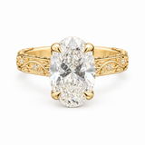 An oval-cut diamond engagement ring with a yellow gold band featuring intricate filigree detailing and small accent diamonds, set against a plain white background.