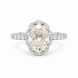 An oval diamond engagement ring with a scalloped halo and a diamond-set band, shown on a clean white background.