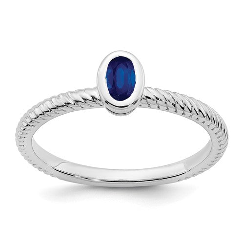 14k white gold oval bezel sapphire ring featuring a central blue sapphire gemstone and elegant jewelry design
