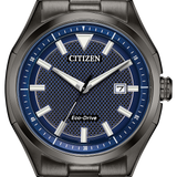 Citizen Eco-Drive watch with a dark gunmetal gray metal case and bracelet, featuring a textured blue dial with silver-tone indices and hands.