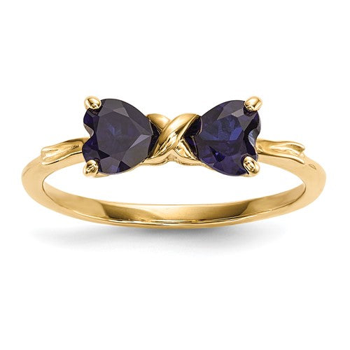 14k gold polished created sapphire bow ring from Solomon Jewelers, featuring a shiny gold band with a blue sapphire bow design.