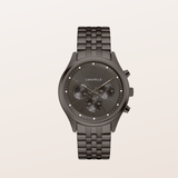 A Caravelle men's chronograph watch featuring a dark gunmetal gray case and a matching dark gray metal link bracelet, set against a solid off-white background.