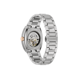 The blue patterned dial with black dial ring and bridges has rose-gold tone hands and markers with luminescent fill and a central aperture revealing the inner workings of the 21-jewel automatic, also visible through a transparent case back.