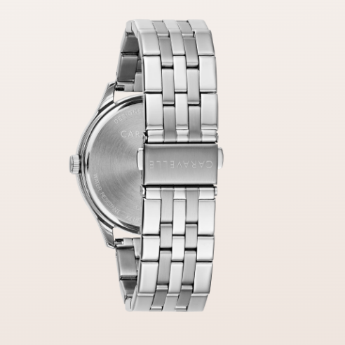 Silver stainless steel watch with a multi-link bracelet, shown from the back on a light beige background. The brand name 'CARAVELLE' is engraved on the clasp and case back.