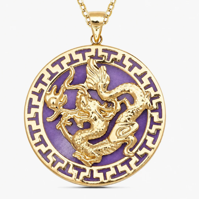 A round gold pendant necklace featuring a raised gold dragon motif over a purple enamel background, with a matching gold Greek key border and chain, shown on a light gray background.