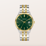 A two-tone Caravelle watch with a dark green dial, gold-tone hands and markers, a fluted gold-tone bezel, and a silver-and-gold metal link bracelet, shown against a light beige background.