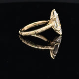 14K yellow gold ring featuring a Dutch marquise-cut lab-grown diamond in a six-prong setting with floral engraving and diamond accents with tulip basket.