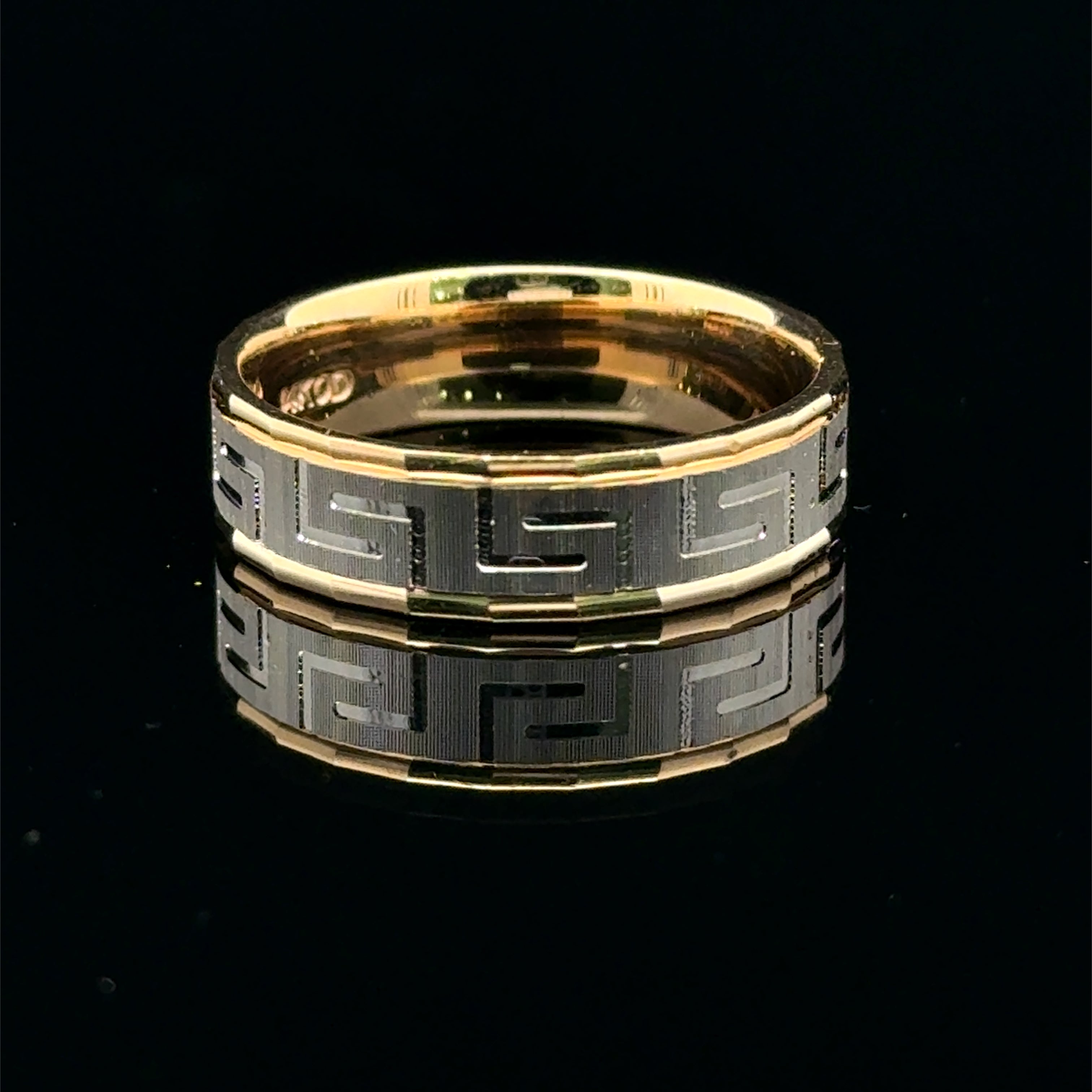 Two-tone yellow and white gold men’s wedding band with a textured Greek-key pattern.