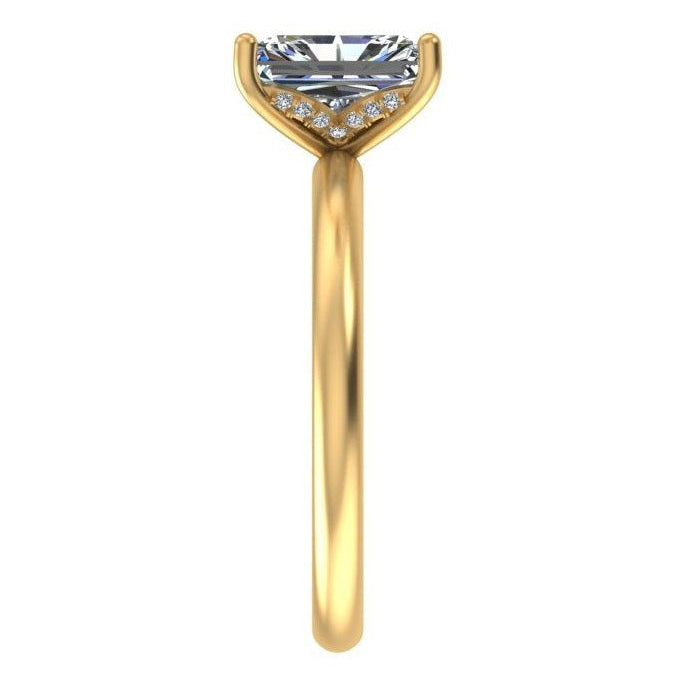 A yellow gold solitaire engagement ring featuring a large rectangular clear gemstone in a prong setting with small accent diamonds along the band, shown against a plain white background.