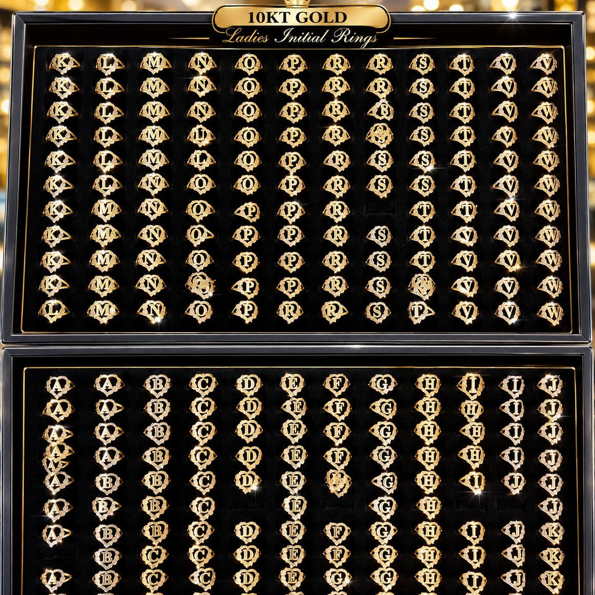 Two open black presentation boxes filled with many gold initial rings, each ring featuring a different letter. The boxes are labeled '10KT GOLD Ladies Initial Rings' at the top.