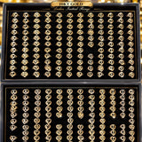 Two open black presentation boxes filled with many gold initial rings, each ring featuring a different letter. The boxes are labeled '10KT GOLD Ladies Initial Rings' at the top.