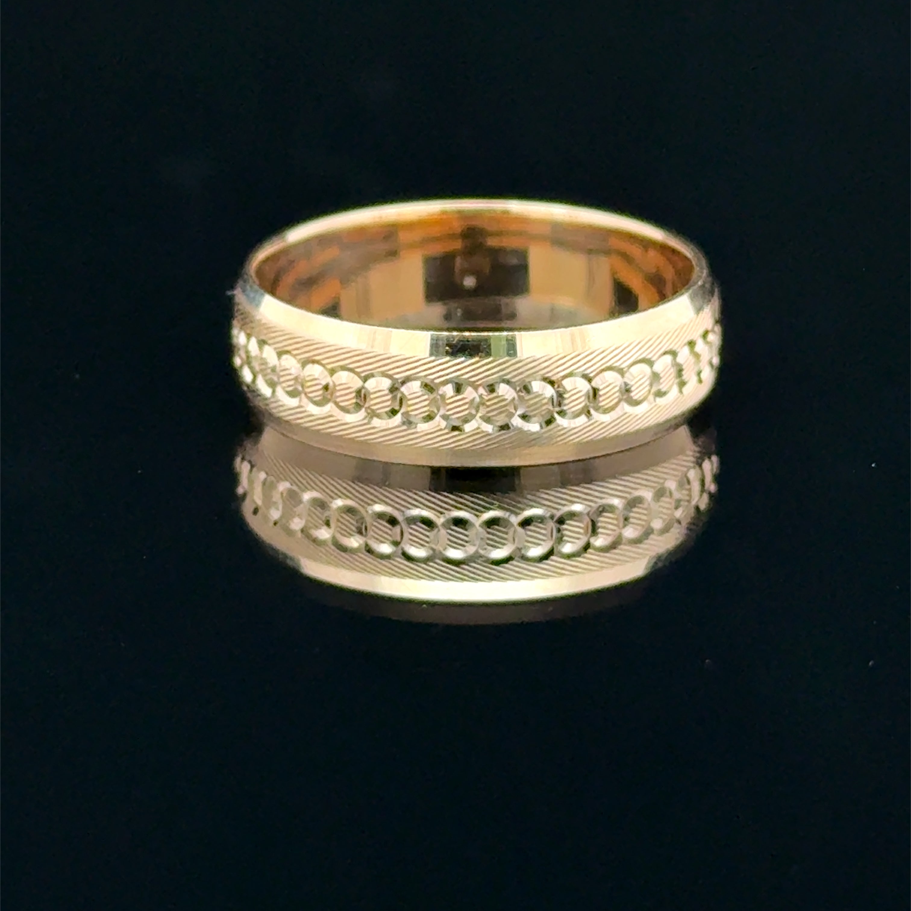 Yellow gold men’s wedding band with circular diamond-cut details and diagonal engraved texture available at Solomon jeweler Kansas.