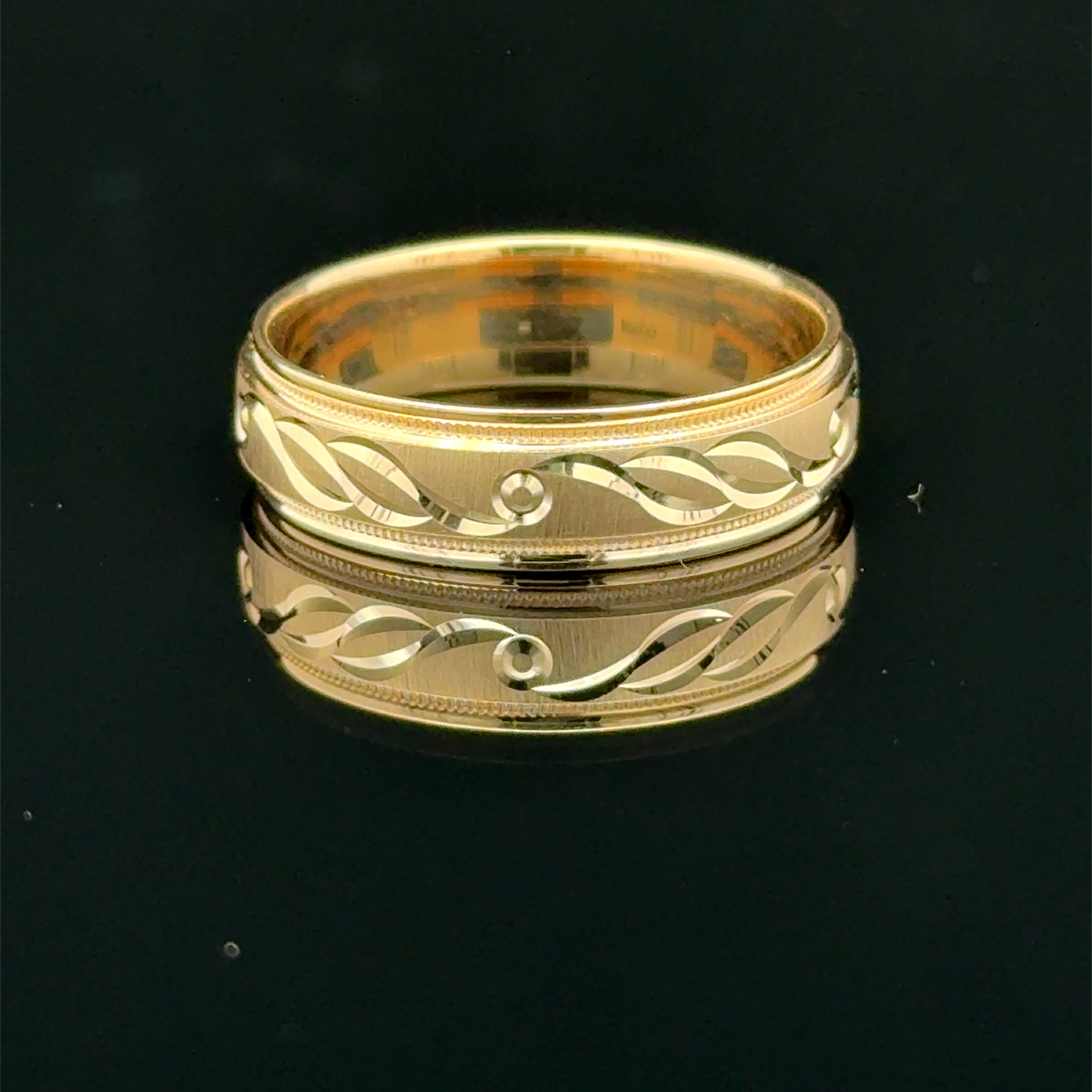 Yellow gold men’s wedding band with polished infinity pattern and milgrain edge available at Solomon Jeweler kansas.
