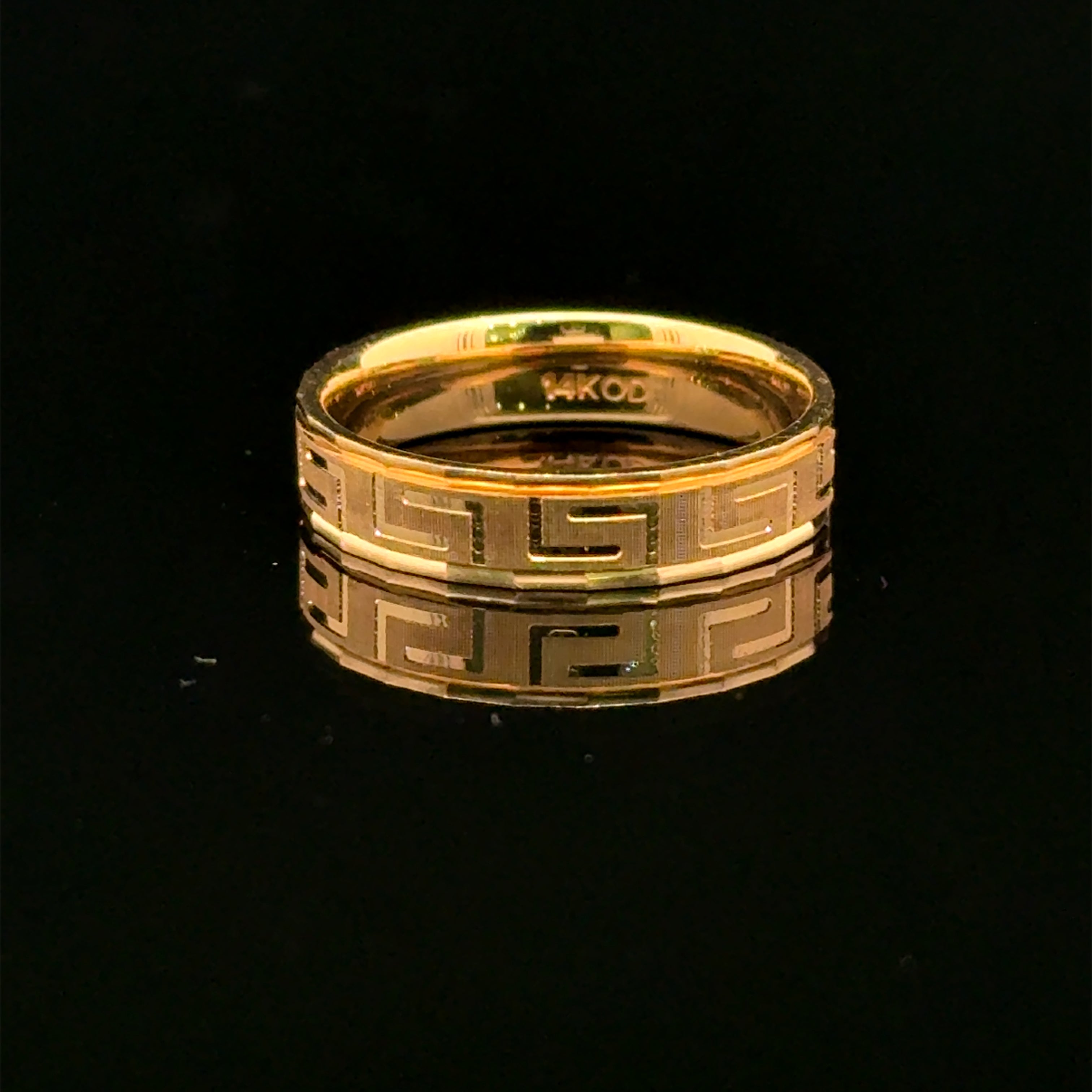 Yellow gold men’s wedding band with a Greek-key pattern, textured center, and smooth polished borders available at Solomon Jeweler Kansas.
