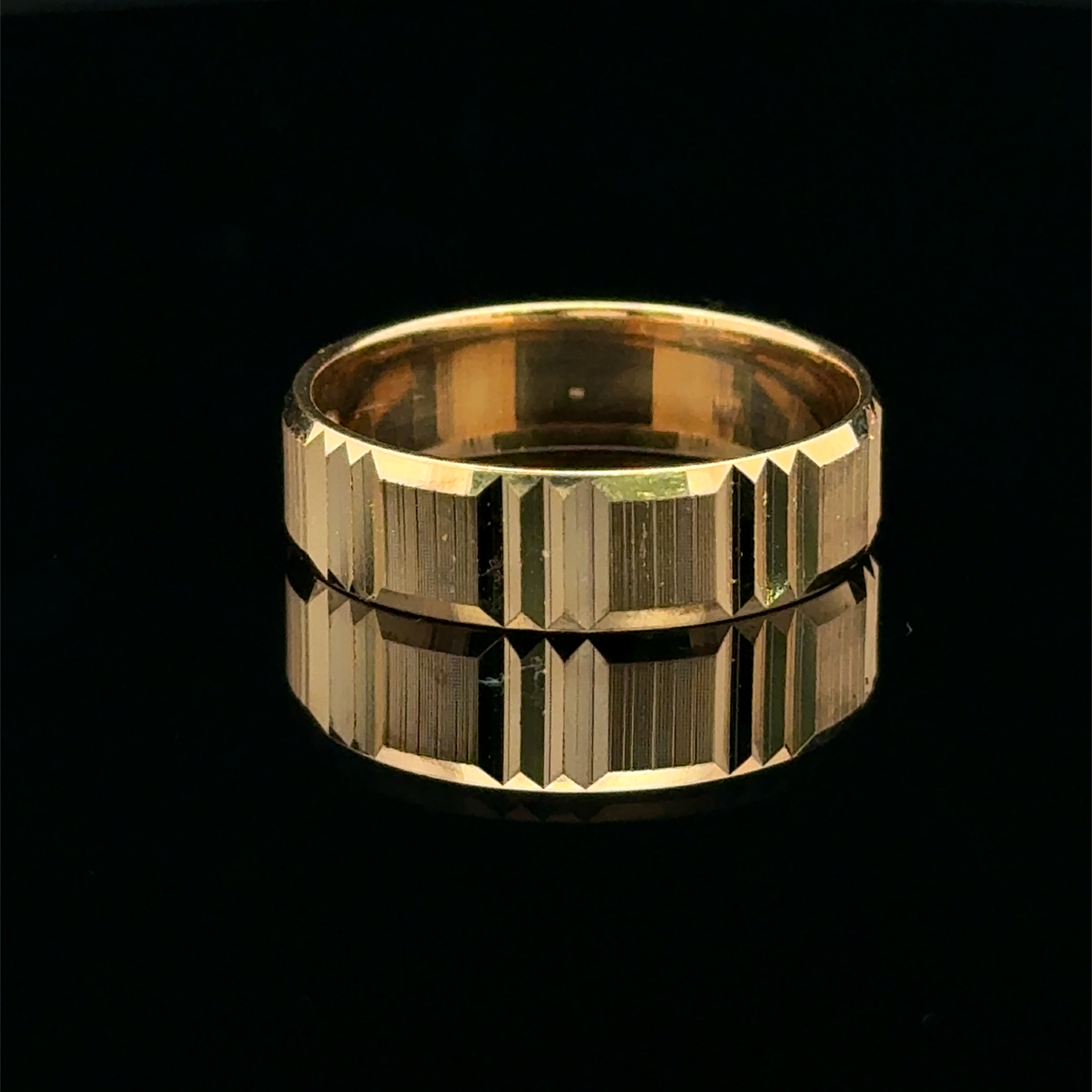 Yellow gold men’s wedding band with geometric diamond-cut panels and vertical textured details.