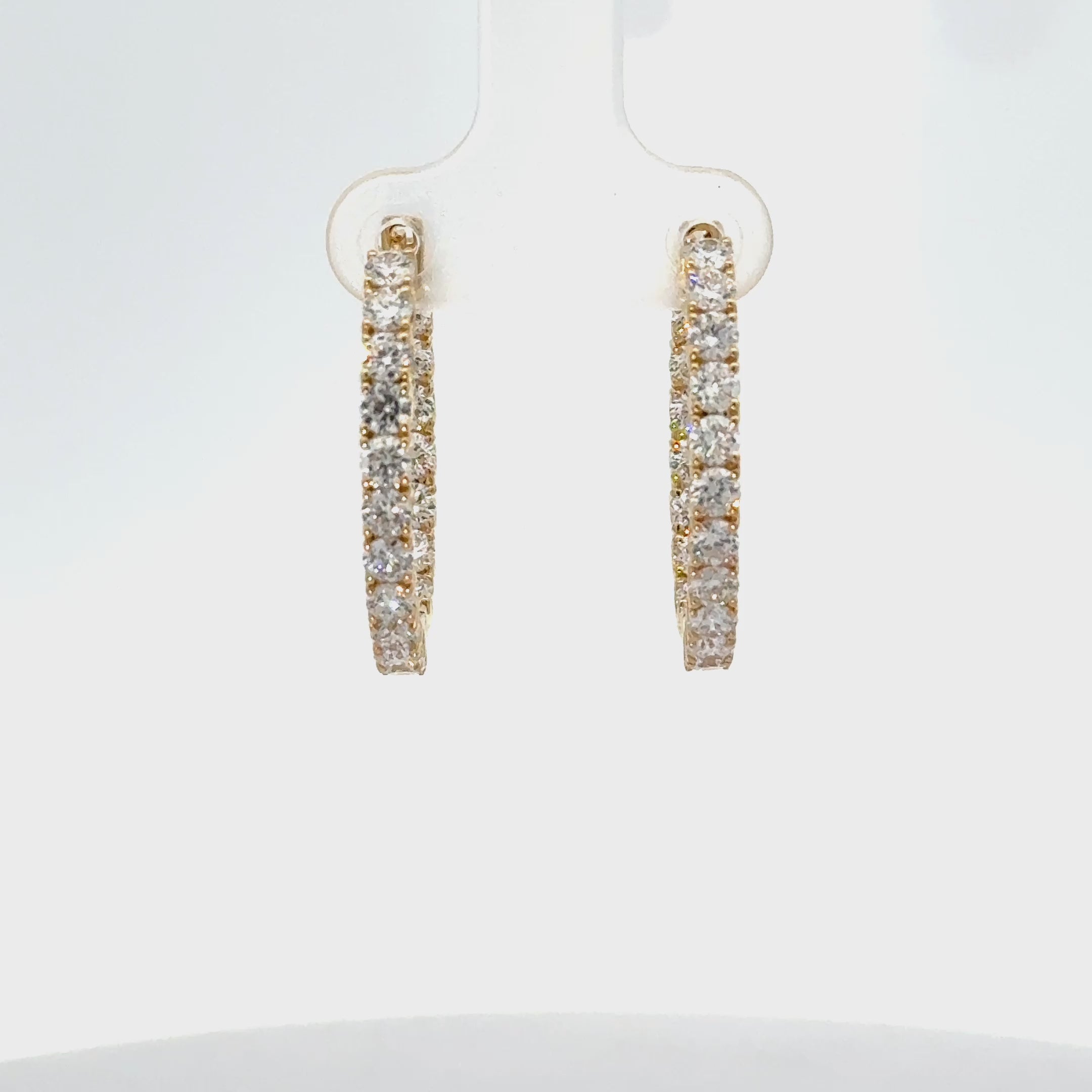 Yellow gold inside-out diamond hoop earrings with round brilliant diamonds and hinged closure.