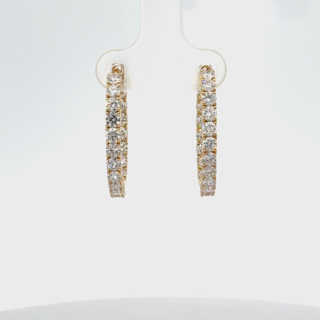 Yellow gold inside-out diamond hoop earrings with round brilliant diamonds and hinged closure.