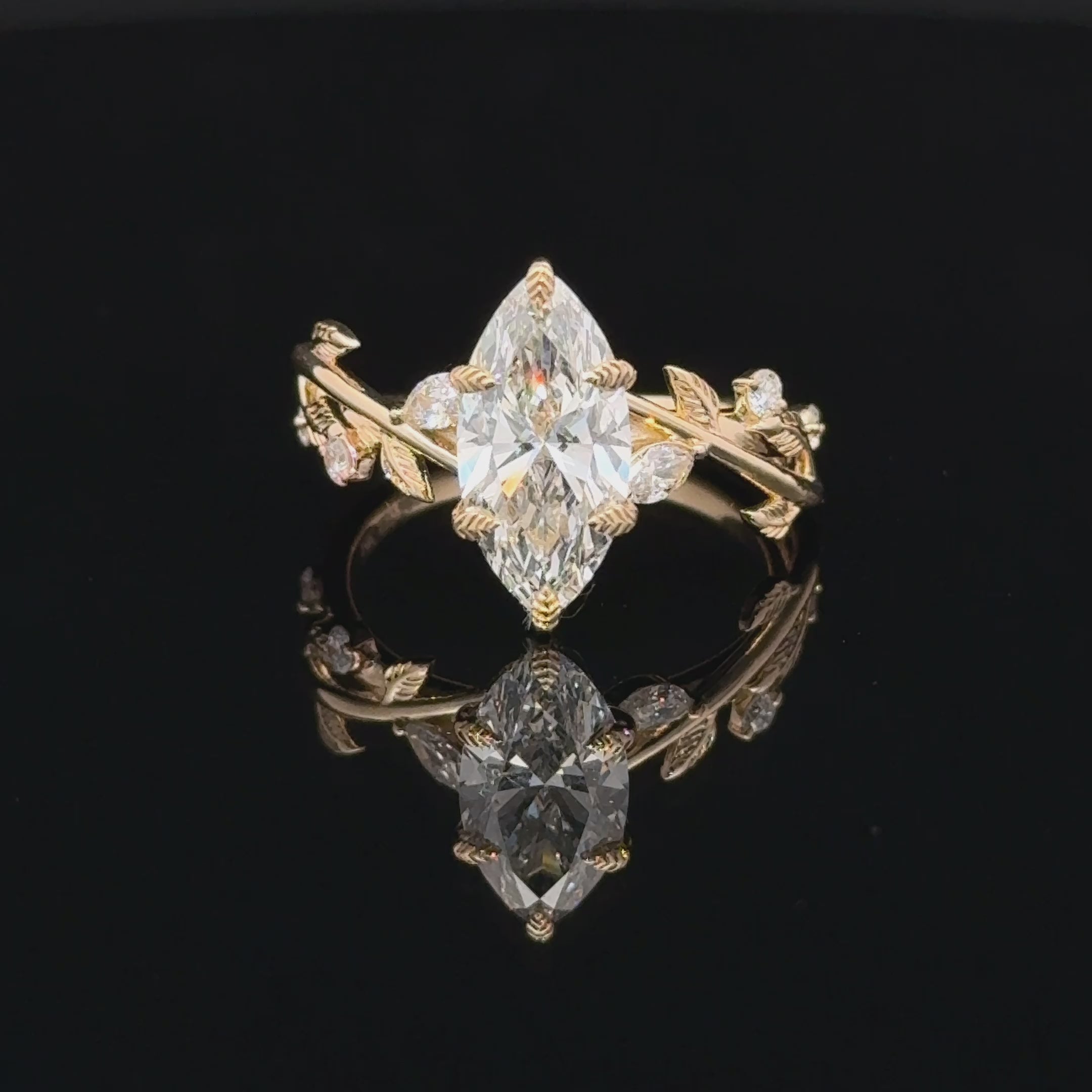 14K yellow gold nature-inspired ring with a marquise-cut lab-grown diamond, leaf prongs, vine details, and diamond accents.