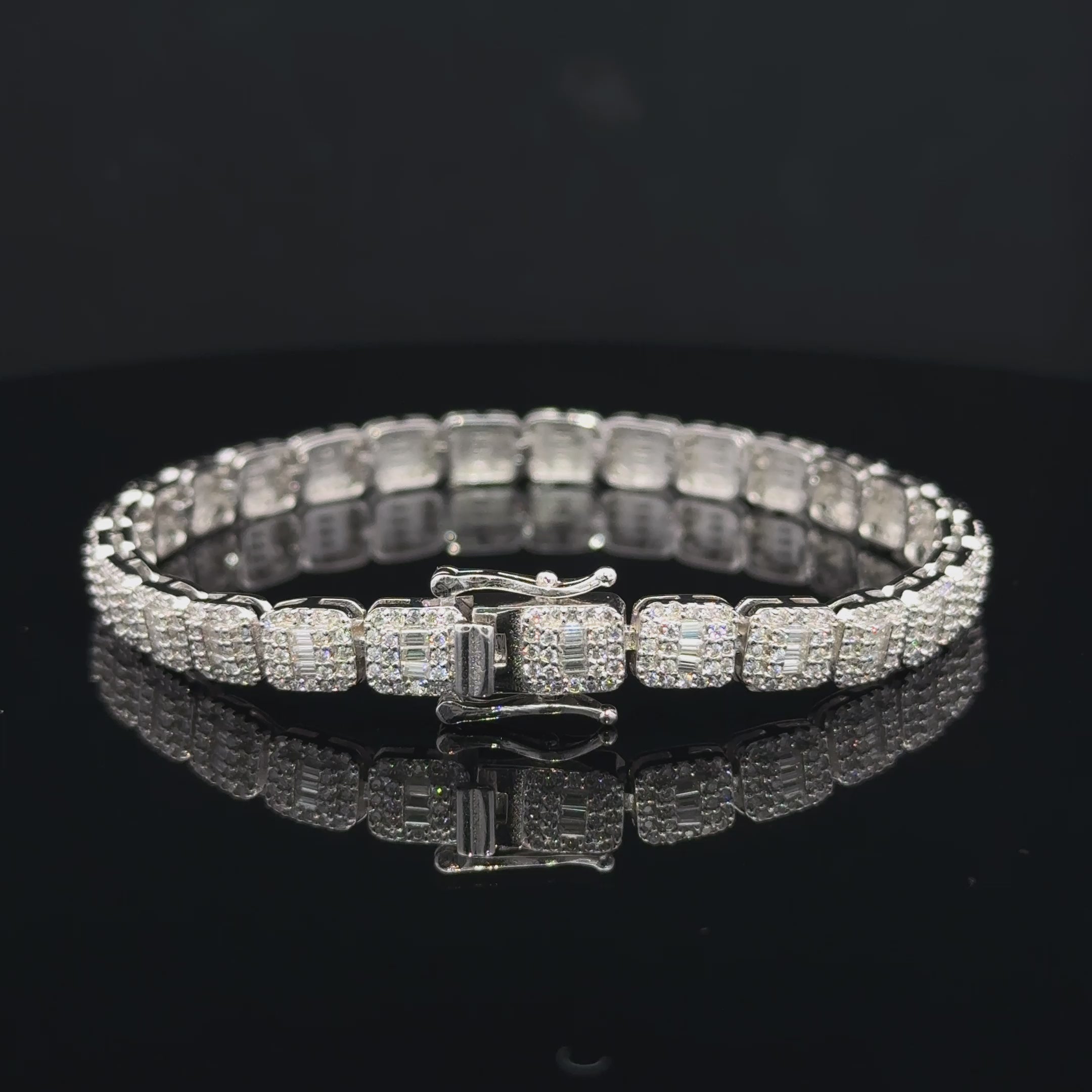 Silver moissanite bracelet with rounded square links, baguette-style centers, round accent stones and a box clasp.