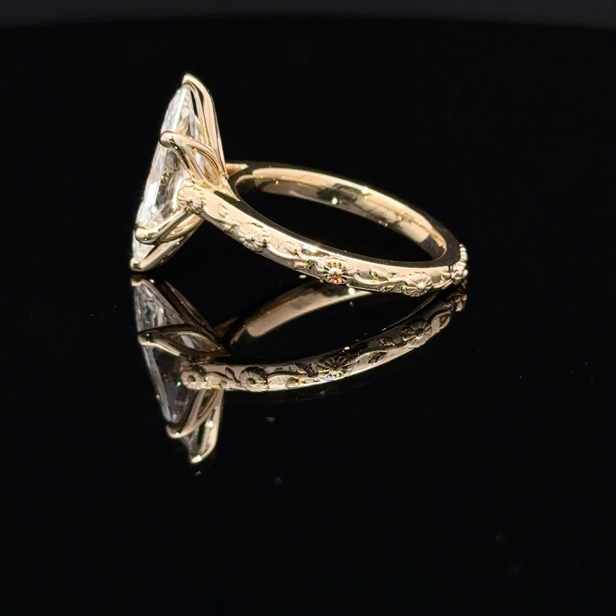 14K yellow gold ring featuring a Dutch marquise-cut lab-grown diamond in a six-prong setting with floral engraving and diamond accents with tulip basket.