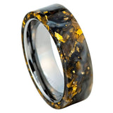 A polished band ring featuring a black and gold marbled resin inlay with embedded gold leaf flakes, set on a solid white background.