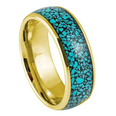 Ring with gold band and turquoise speckled design on a white background