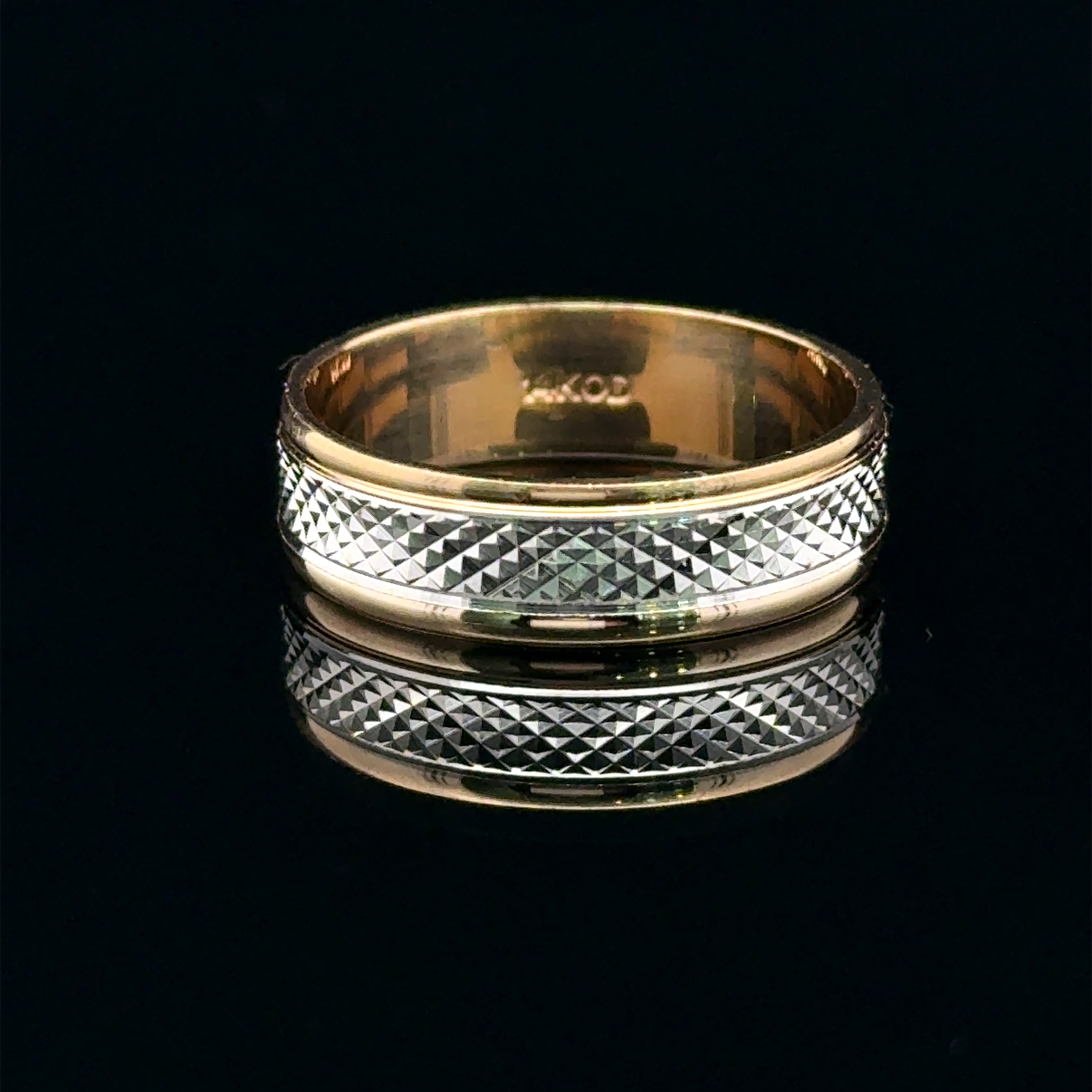 Two-tone men’s wedding band with a faceted white-gold center and polished yellow-gold edges available at Solomon jeweler Kansas.