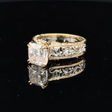 14K two-tone gold ring with a 3-carat cushion-cut lab-grown diamond, filigree scrollwork and round diamond accents on a white background
