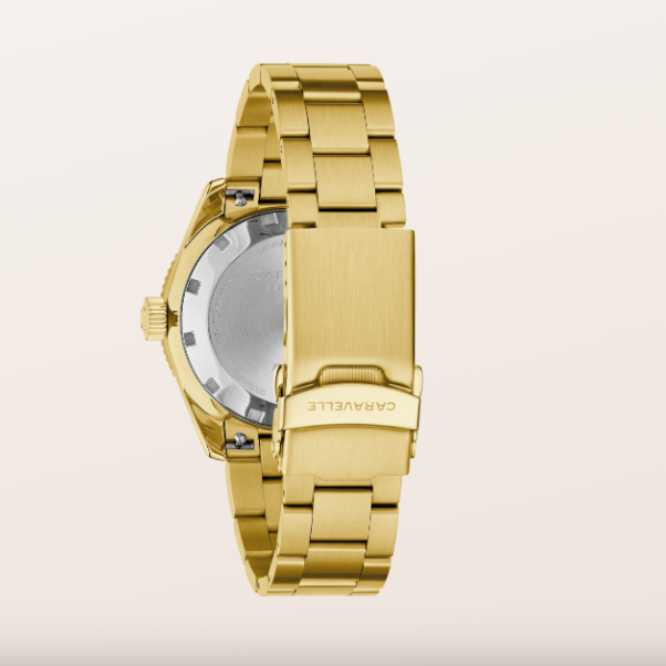 Gold-tone metal watch band and case back shown from the rear, with the brand name CARAVELLE engraved on the clasp, set against a solid off-white background.