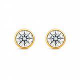Close-up of round bezel-set lab diamond stud earring in 14K gold.