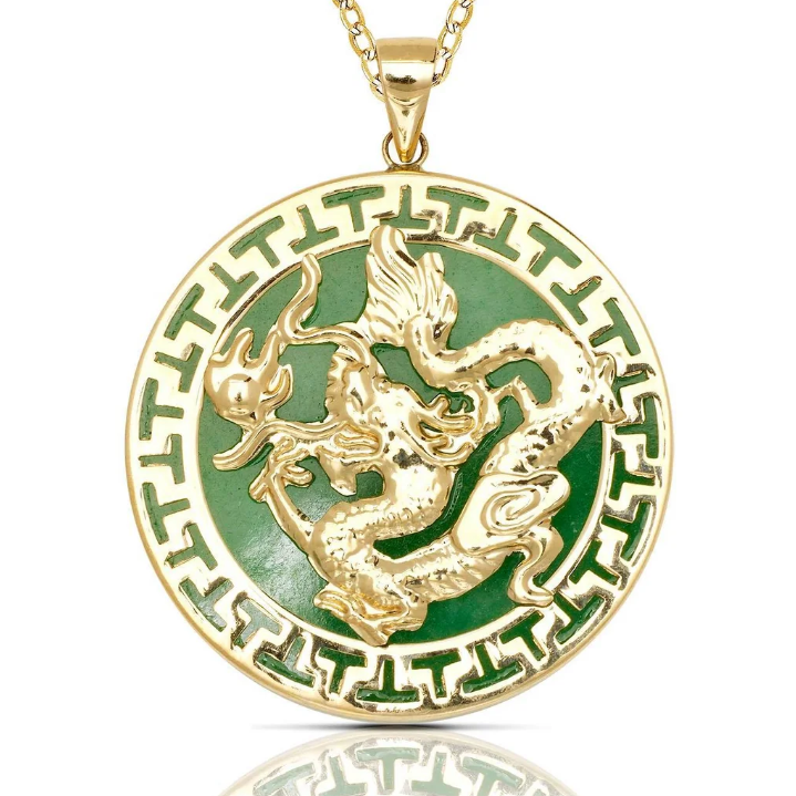 A round gold pendant necklace featuring a raised gold dragon motif over a green enamel background, with a matching green and gold Greek key border. The pendant is suspended from a gold chain on a clean white background with a subtle reflection below.